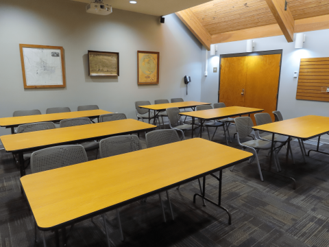 Room with 6 tables and 3 chairs at each table 